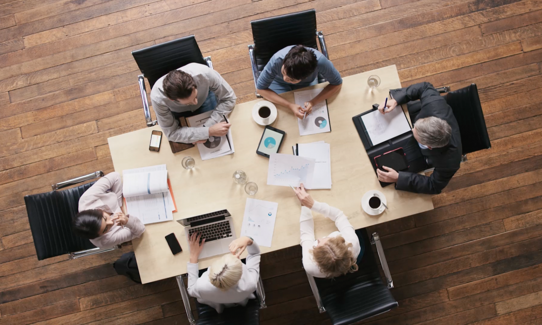 Aerial shot of 6 people meeting around a table